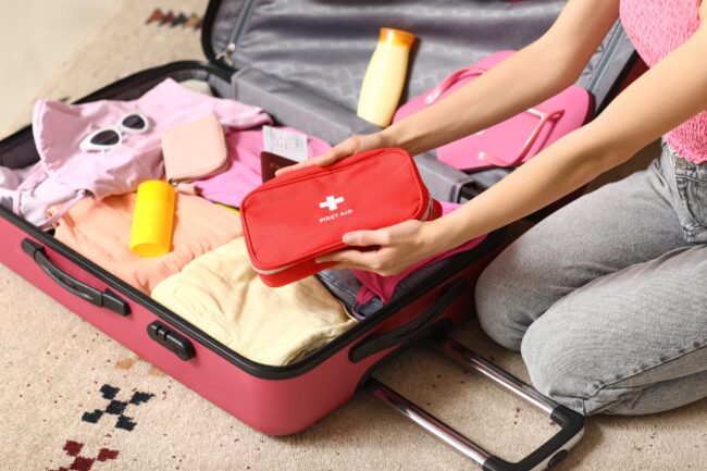Young,Woman,With,Suitcase,And,First,Aid,Kit,Sitting,On